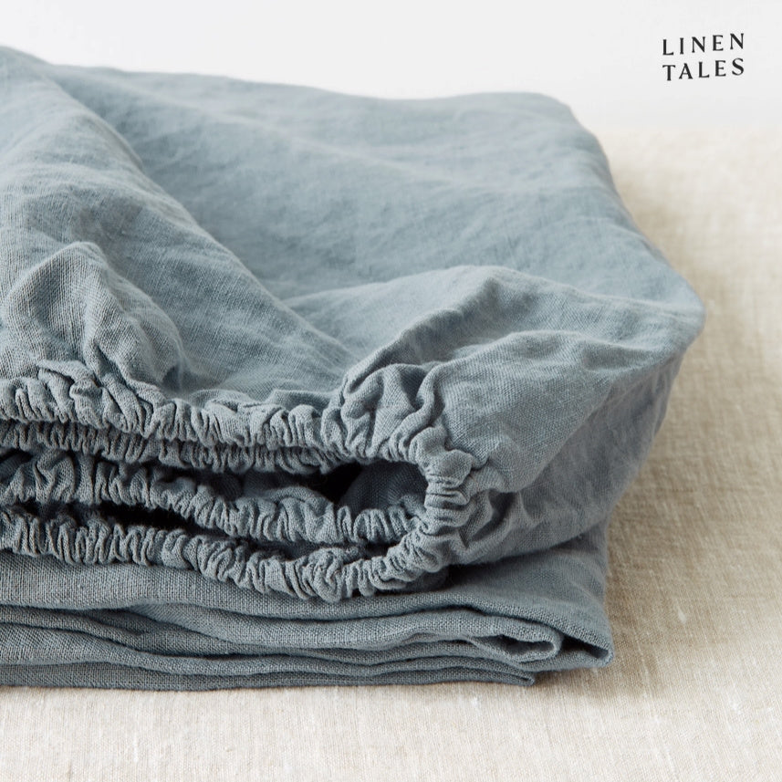 A calming blue fog fitted sheet, crafted from certified 100% pure linen sustainably woven, breathable, and stone-washed for cloud-like softness.