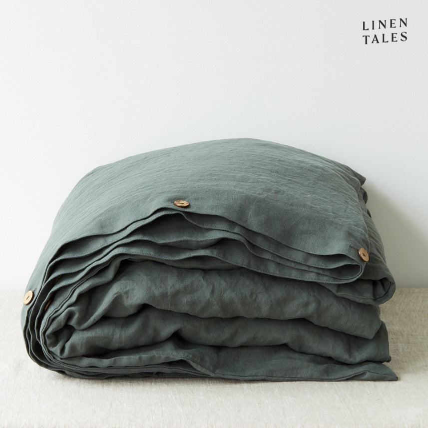 A folded 100% pure linen duvet cover in rich forest green, reminiscent of lush woodland hues.