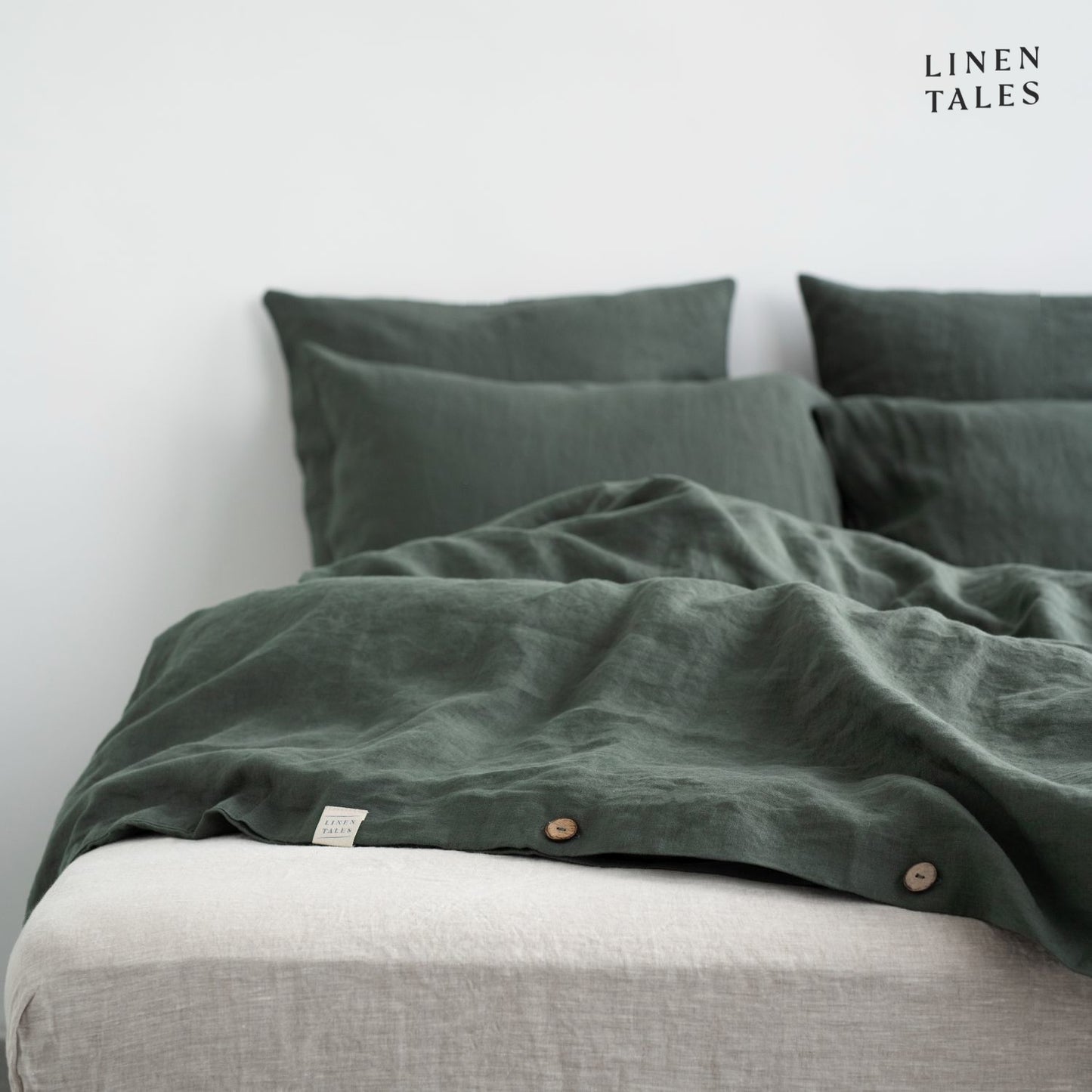 Close-up of Forest Green linen duvet cover opening, featuring natural wooden buttons for a refined and functional finish.