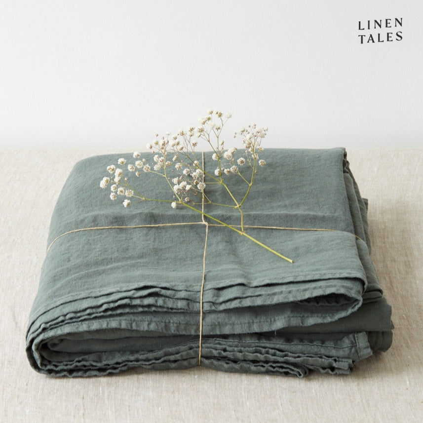 A folded fitted 100% pure linen flat sheet in rich forest green, reminiscent of lush woodland tones.