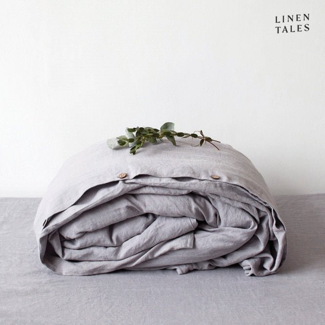 A folded 100% pure linen duvet cover in soft light grey, offering subtle texture and a serene, neutral tone.