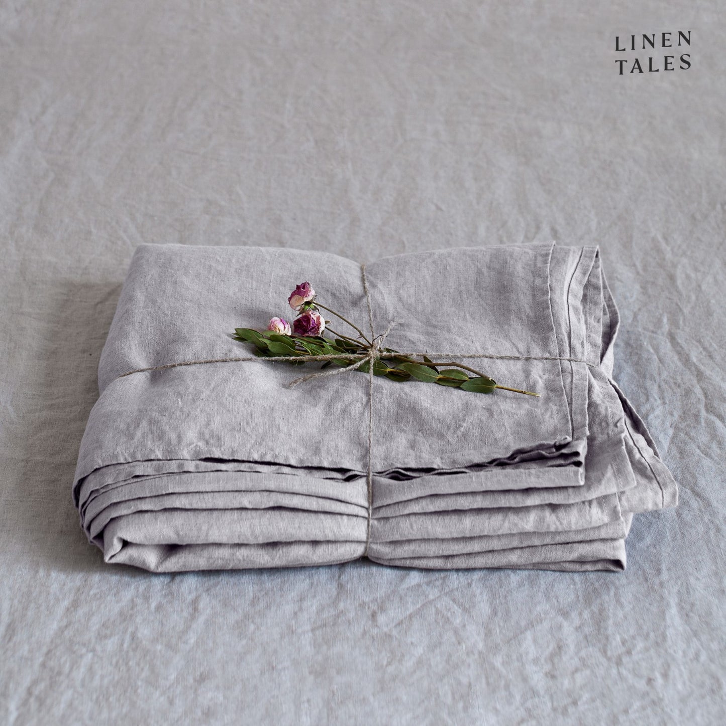A folded fitted 100% pure linen flat sheet in subtle light grey, with delicate texture and a calming tone.