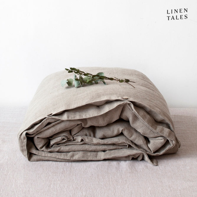 A folded 100% pure linen duvet cover in organic natural flax, reflecting sustainable craftsmanship and timeless appeal.