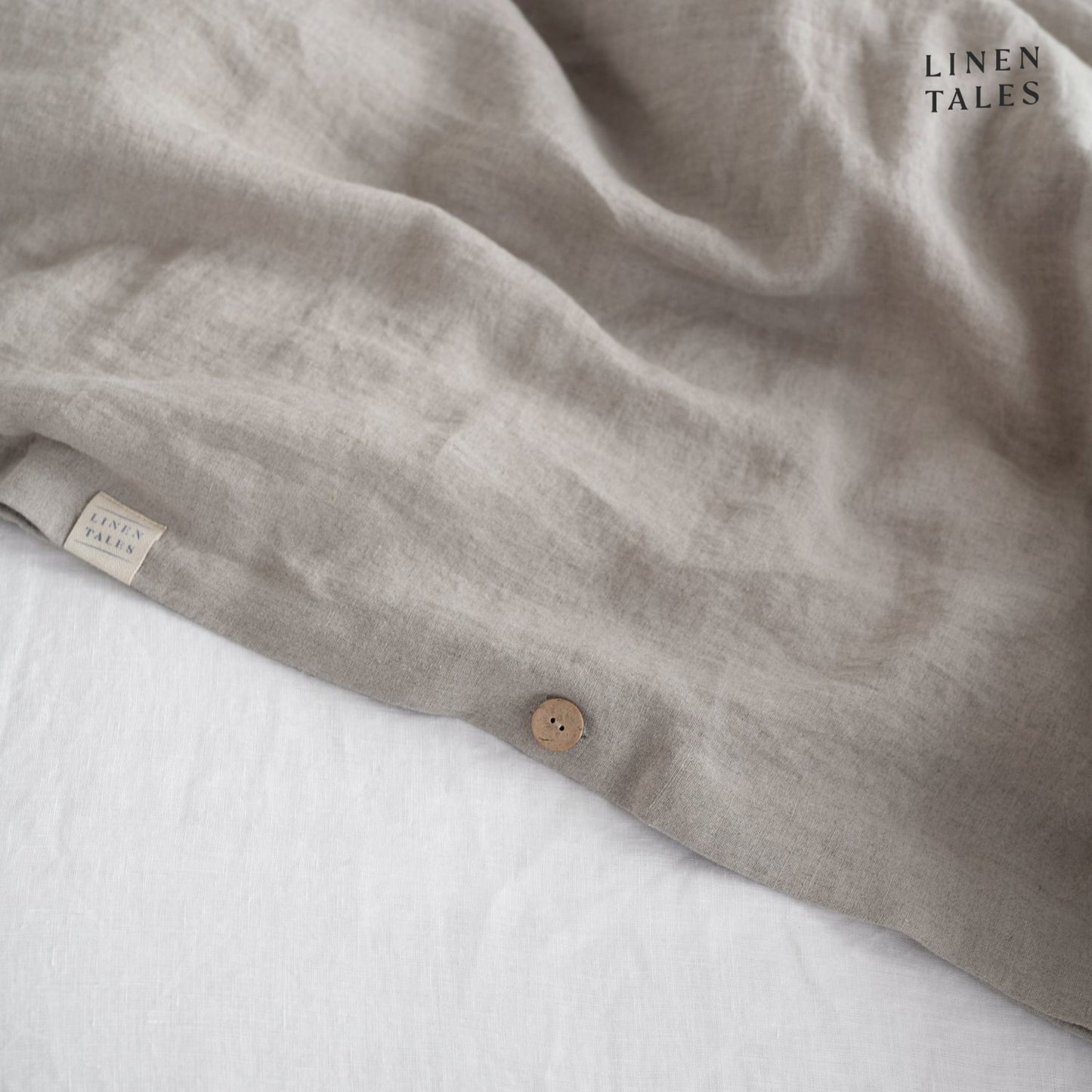 Close-up of Natural linen duvet cover opening, featuring natural wooden buttons for a refined and functional finish.