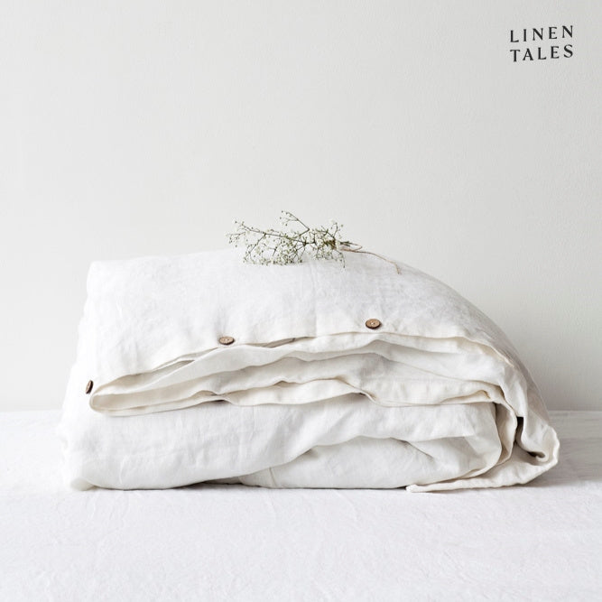 A neatly folded 100% pure linen duvet cover in crisp white, highlighting its airy texture and soft drape.