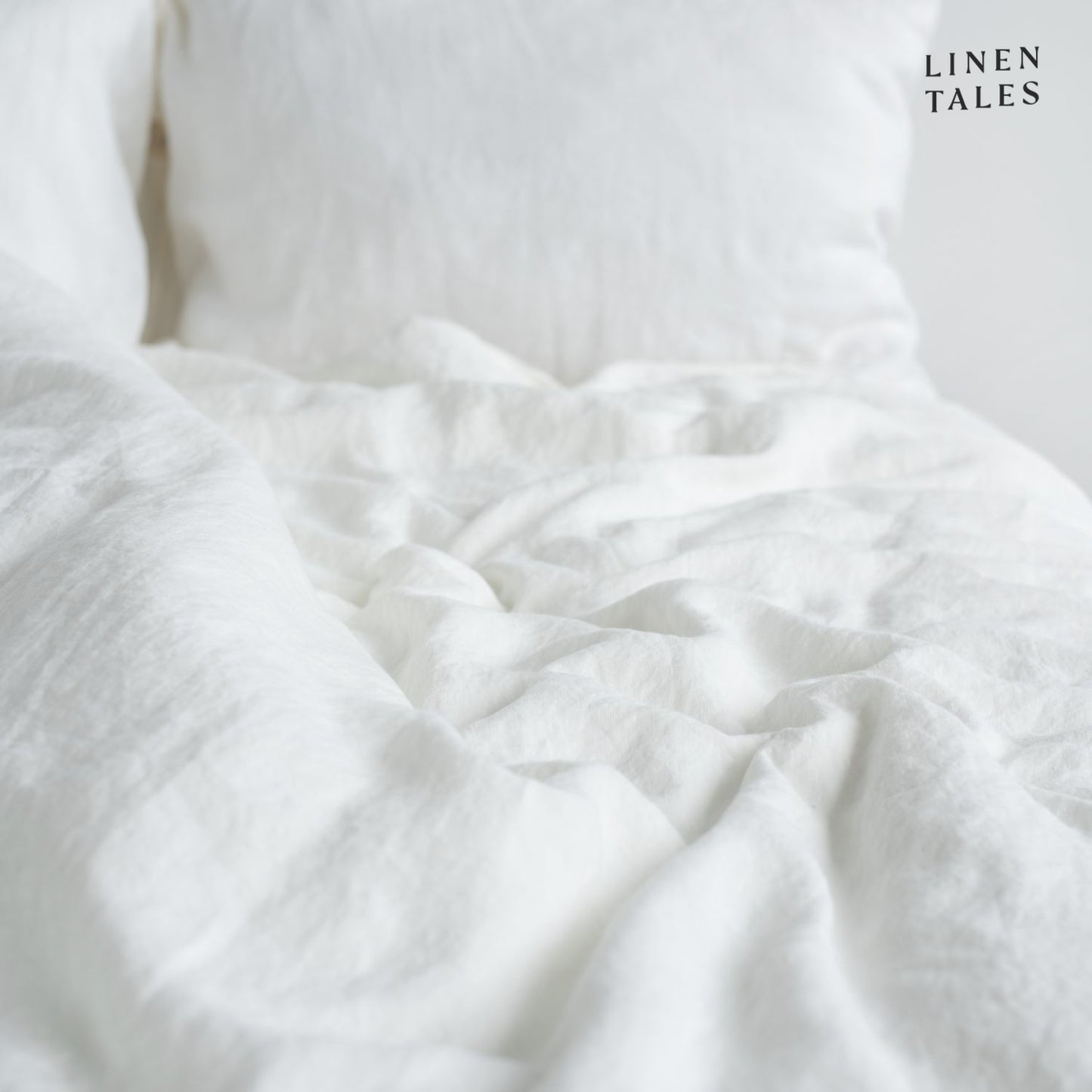 Softly ruffled White linen duvet cover and pillowcase, highlighting relaxed elegance and breathable fabric.