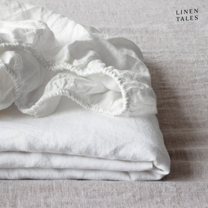 A neatly folded white fitted sheet, crafted from certified 100% pure linen breathable, sustainable, and stone-washed for soft, lasting comfort.