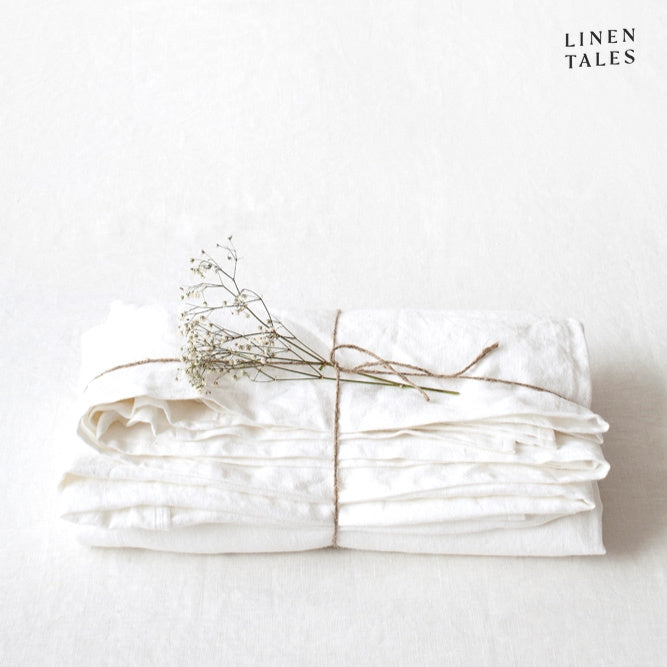 A neatly folded fitted 100% pure linen flat sheet in crisp white, showcasing its soft, breathable texture.