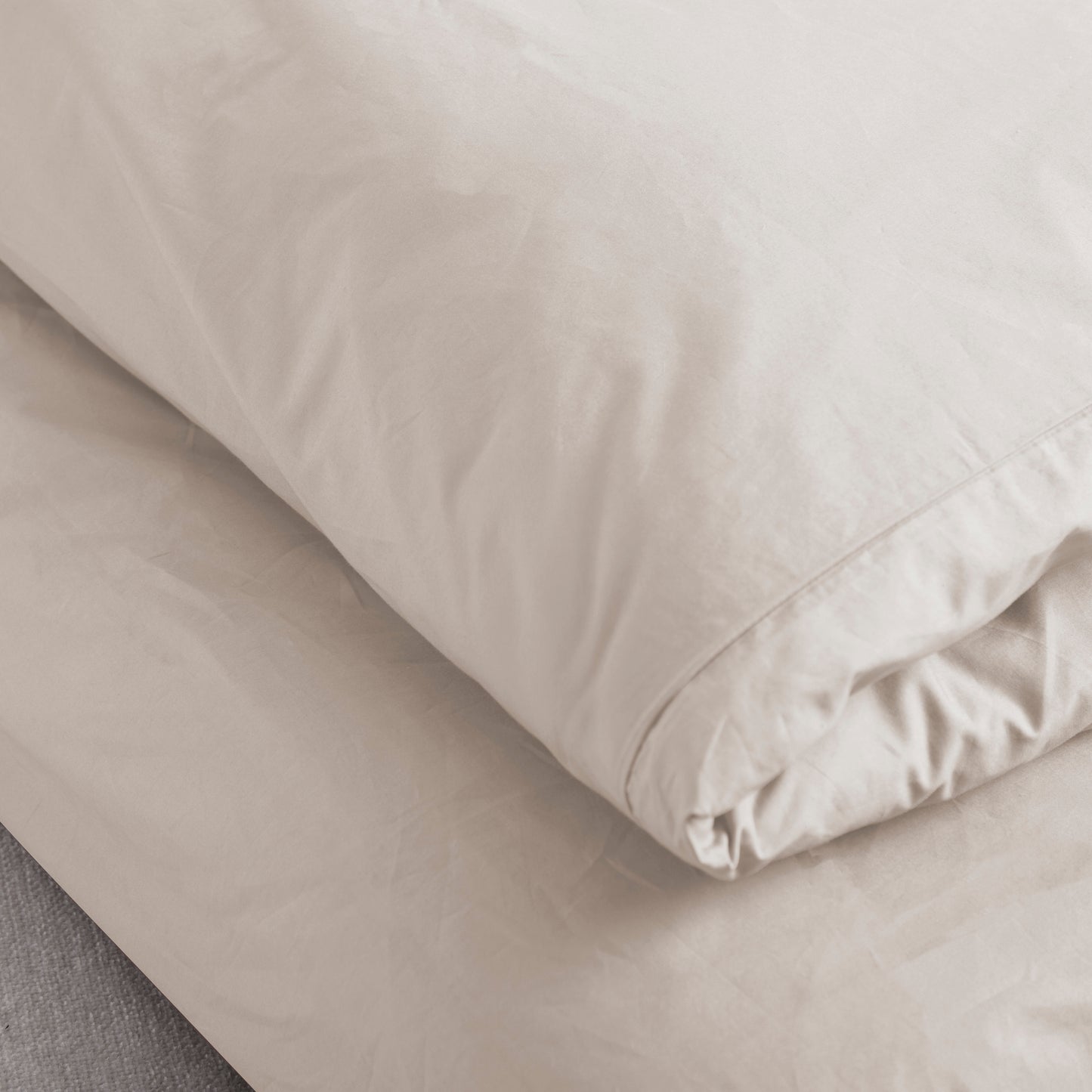 Driftwood colour folded Linen Bay Duvet on a bed with a neutral background – Linen Bay UK