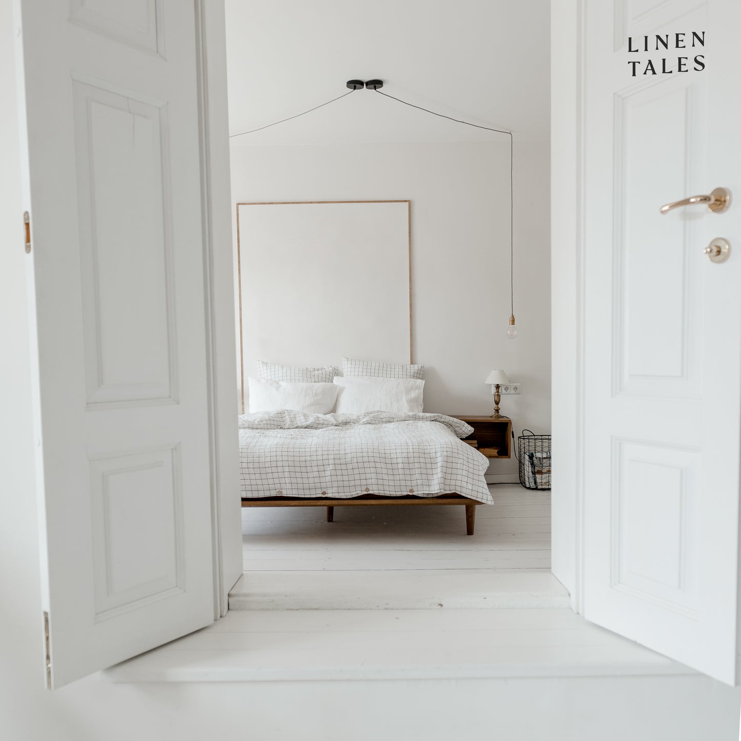 A fully made linen bed featuring a crisp white grid duvet cover and matching white pillowcases elegant simplicity meets breathable comfort.