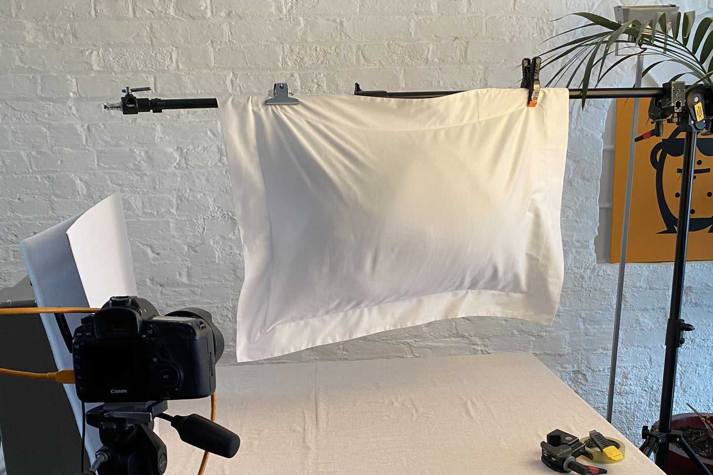 White sateen Oxford pillowcase hanging from clip, showcasing the elegant corners and stitched Oxford edging detail.
