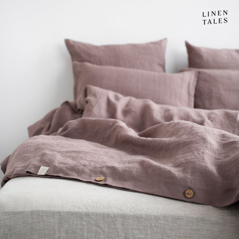 Close-up of Ashes of Roses linen duvet cover opening, featuring natural wooden buttons for a refined and functional finish.  