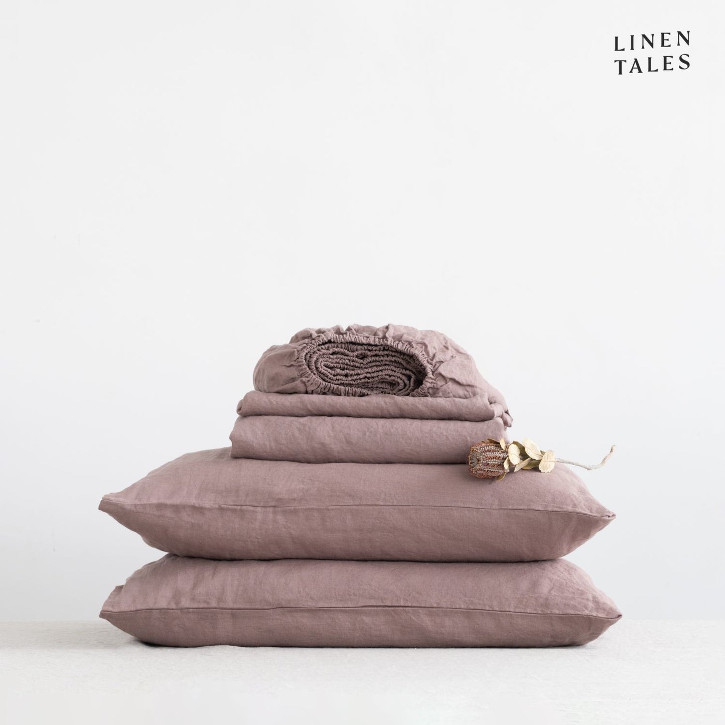 Close-up of 100% linen bedding in Ashes of Roses, showcasing the soft texture of the flat sheet, fitted sheet, and pillowcase – breathable and timeless.