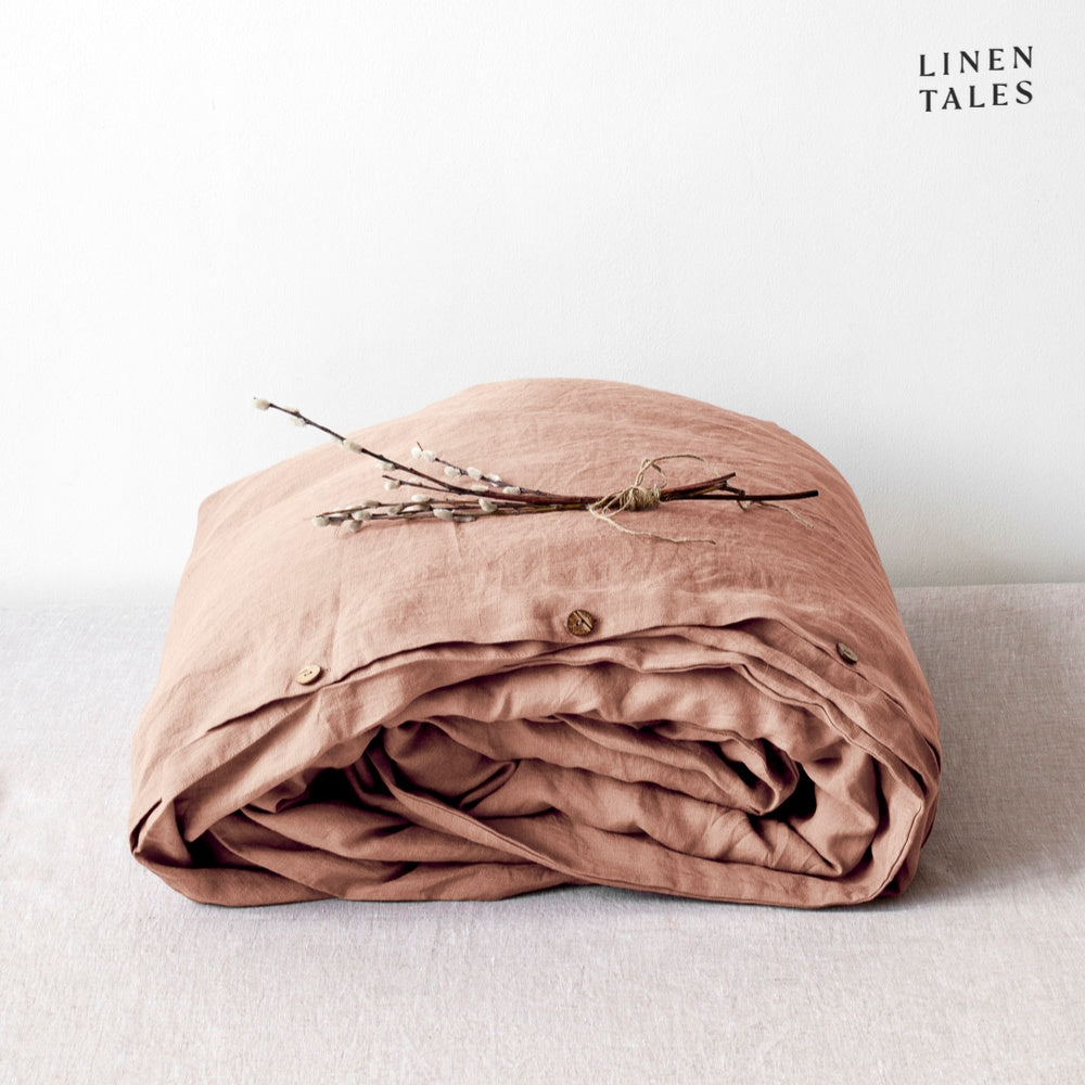 A folded 100% pure linen duvet cover in creamy cafe creme, radiating warmth and effortless sophistication