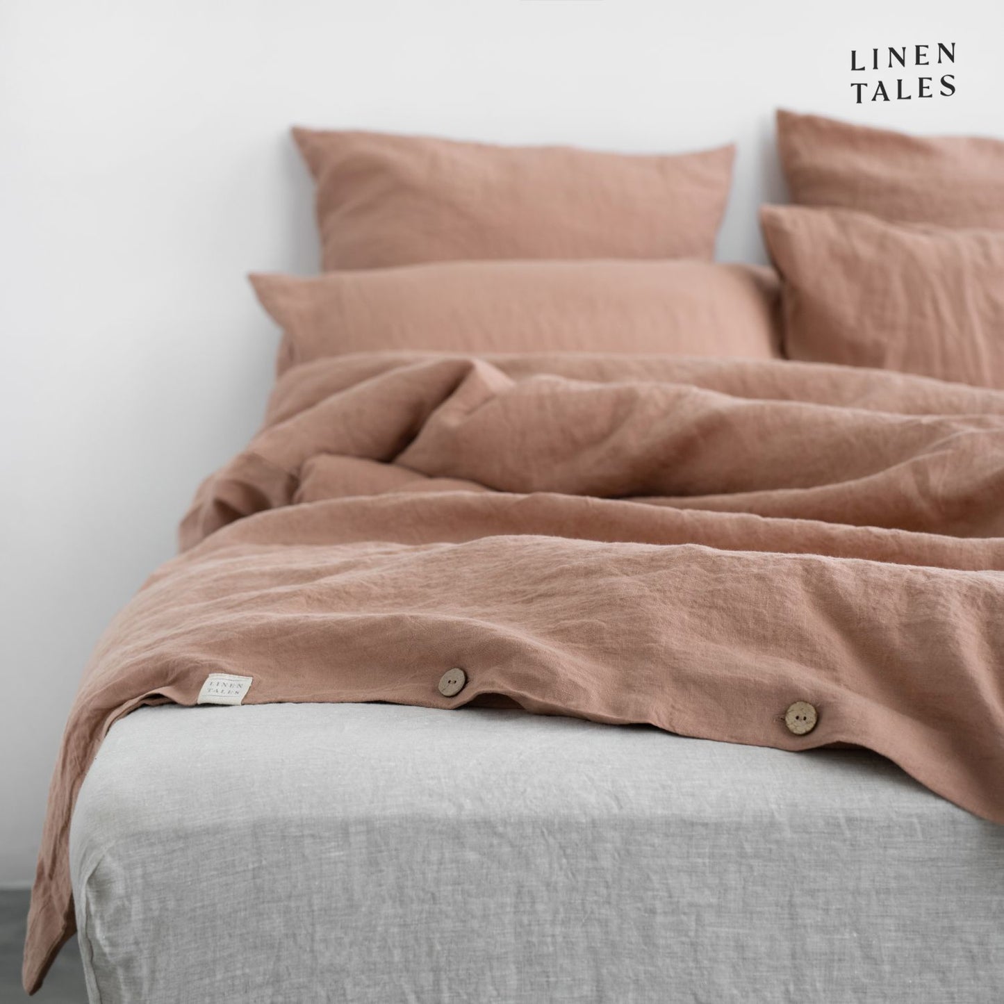 Close-up of Cafe Creme linen duvet cover opening, featuring natural wooden buttons for a refined and functional finish. 