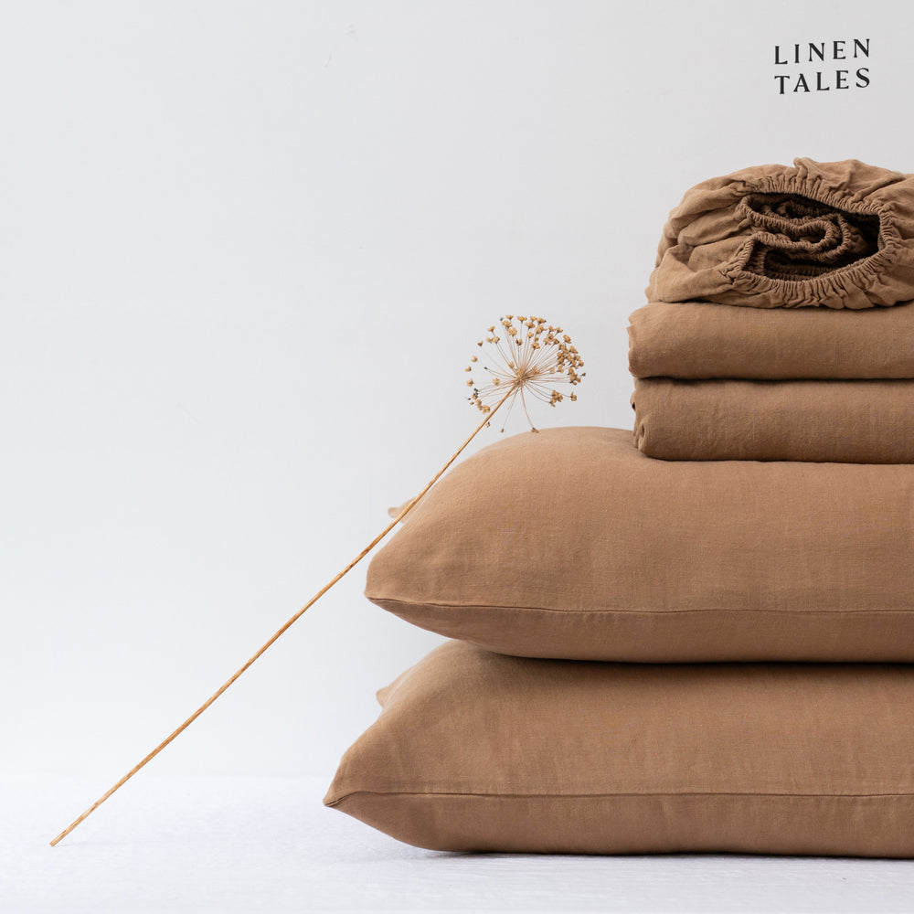 Close-up of 100% linen bedding in Camel, showcasing the soft texture of the flat sheet, fitted sheet, and pillowcase – breathable and timeless.
