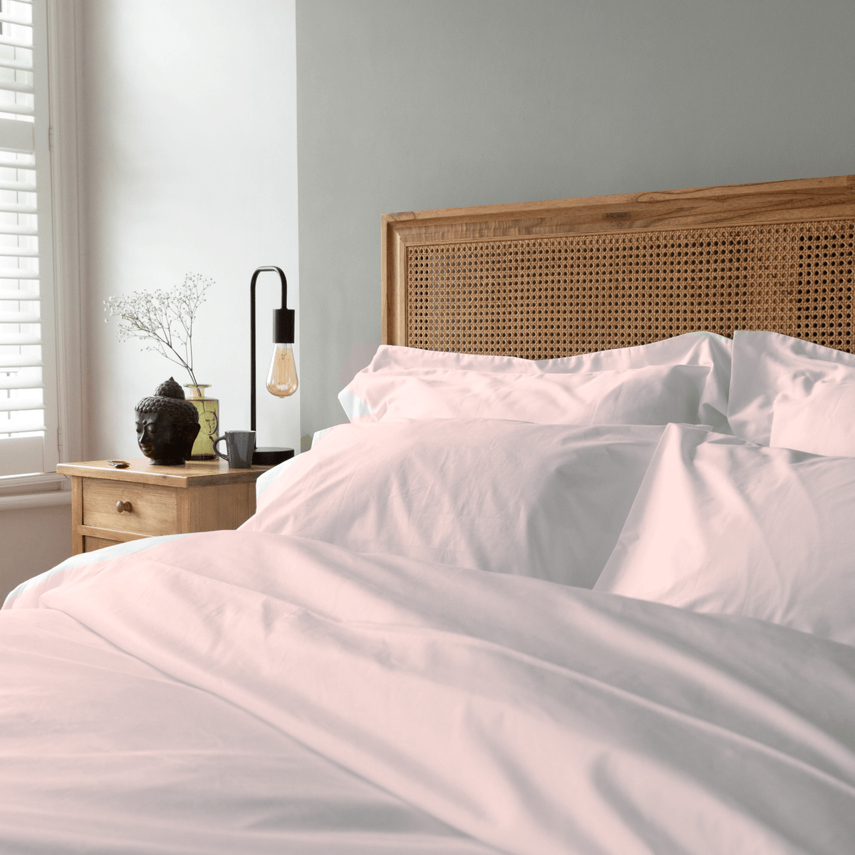 pink blush bedding across bed in sunlight