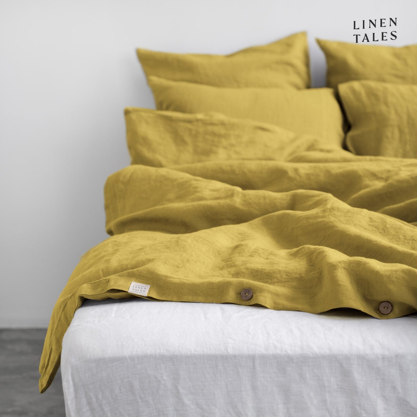 Layered look of Lemon Curry linen duvet set with coordinating sheet, offering effortless comfort and timeless style. 