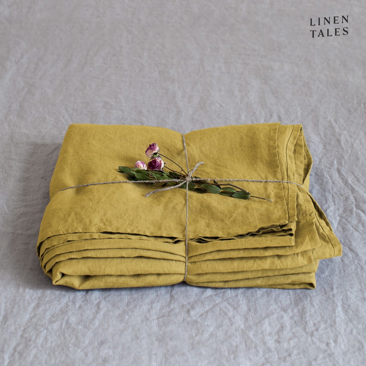 A folded fitted 100% pure linen flat sheet in bold lemon curry, a vibrant golden hue full of warmth.