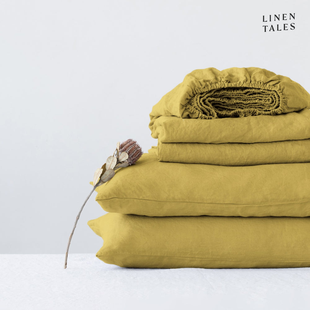 Minimalist bedroom featuring pure linen bed sheets in Lemon Curry with a matching pillowcase – refined simplicity meets luxurious softness