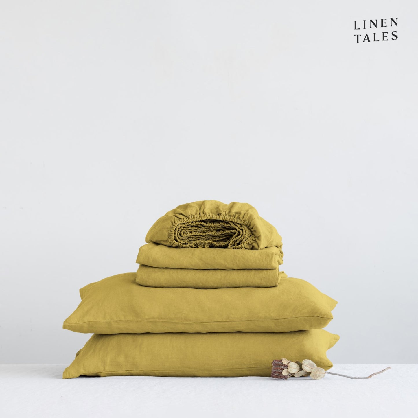 Close-up of 100% linen bedding in Lemon Curry, showcasing the soft texture of the flat sheet, fitted sheet, and pillowcase – breathable and timeless.