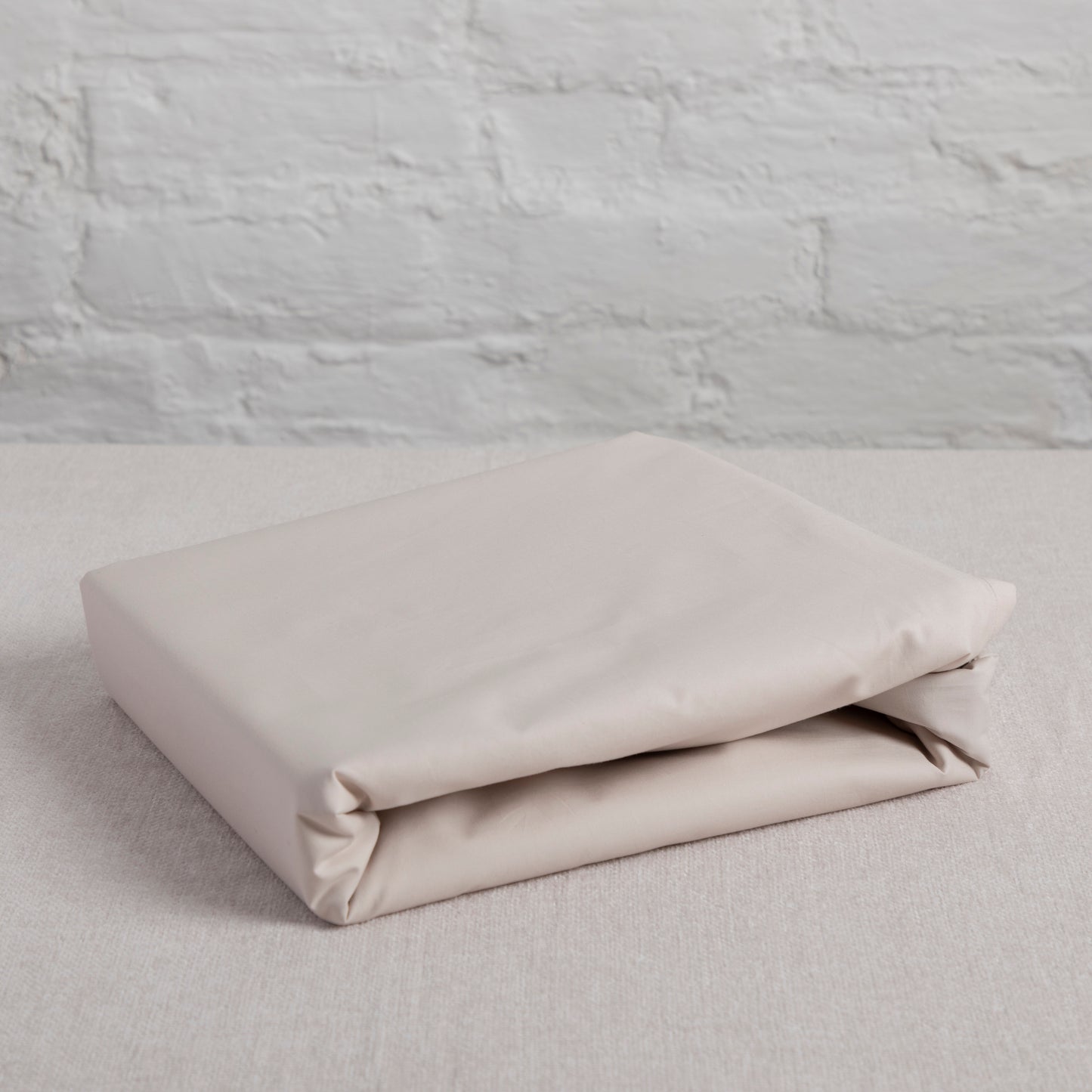 100% Pure GOTS certified organic cotton, Driftwood Flat Sheet Folded on a textured grey surface