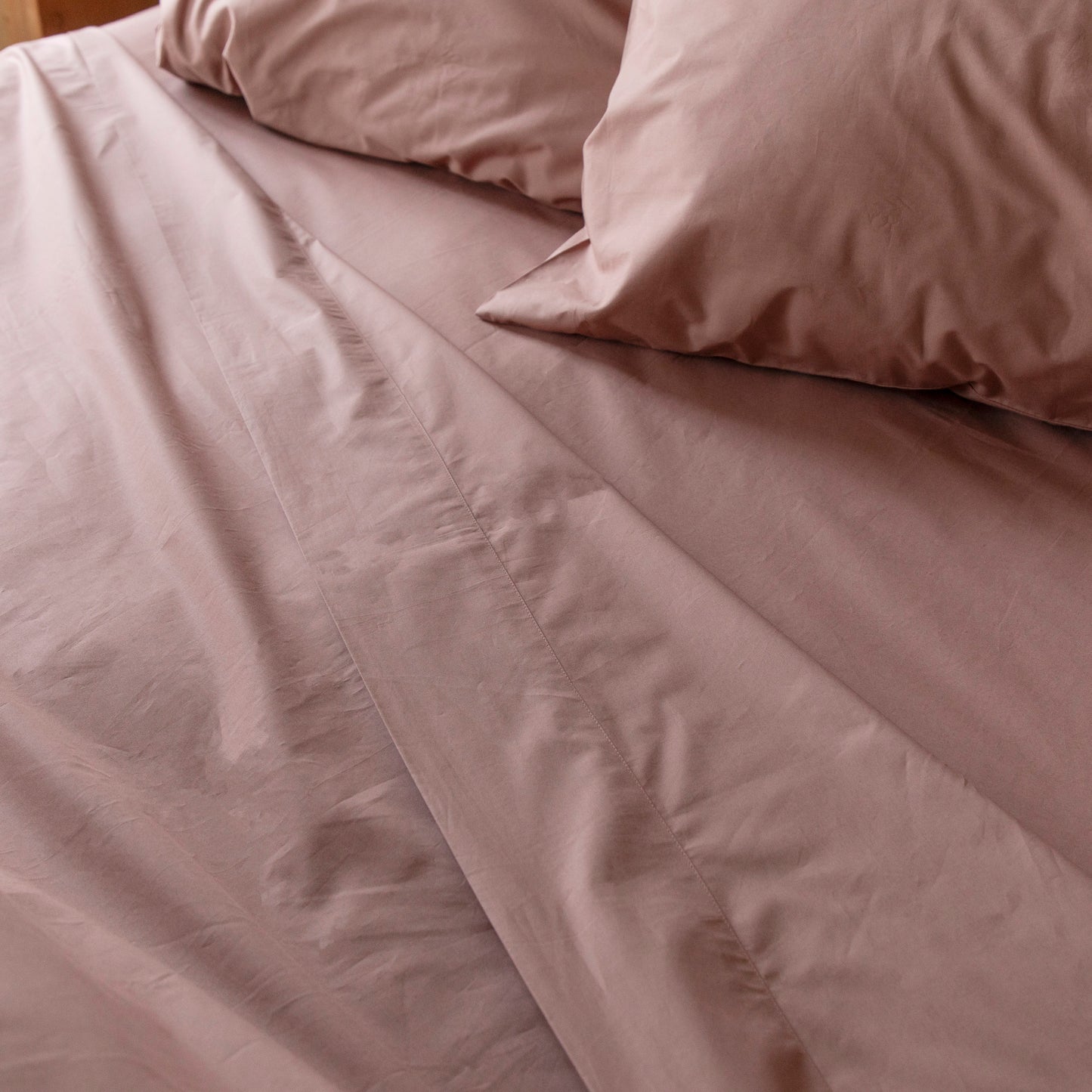 Flat Sheet drawn back on bed with Dune Shadow matching pillow cases and fitted sheet