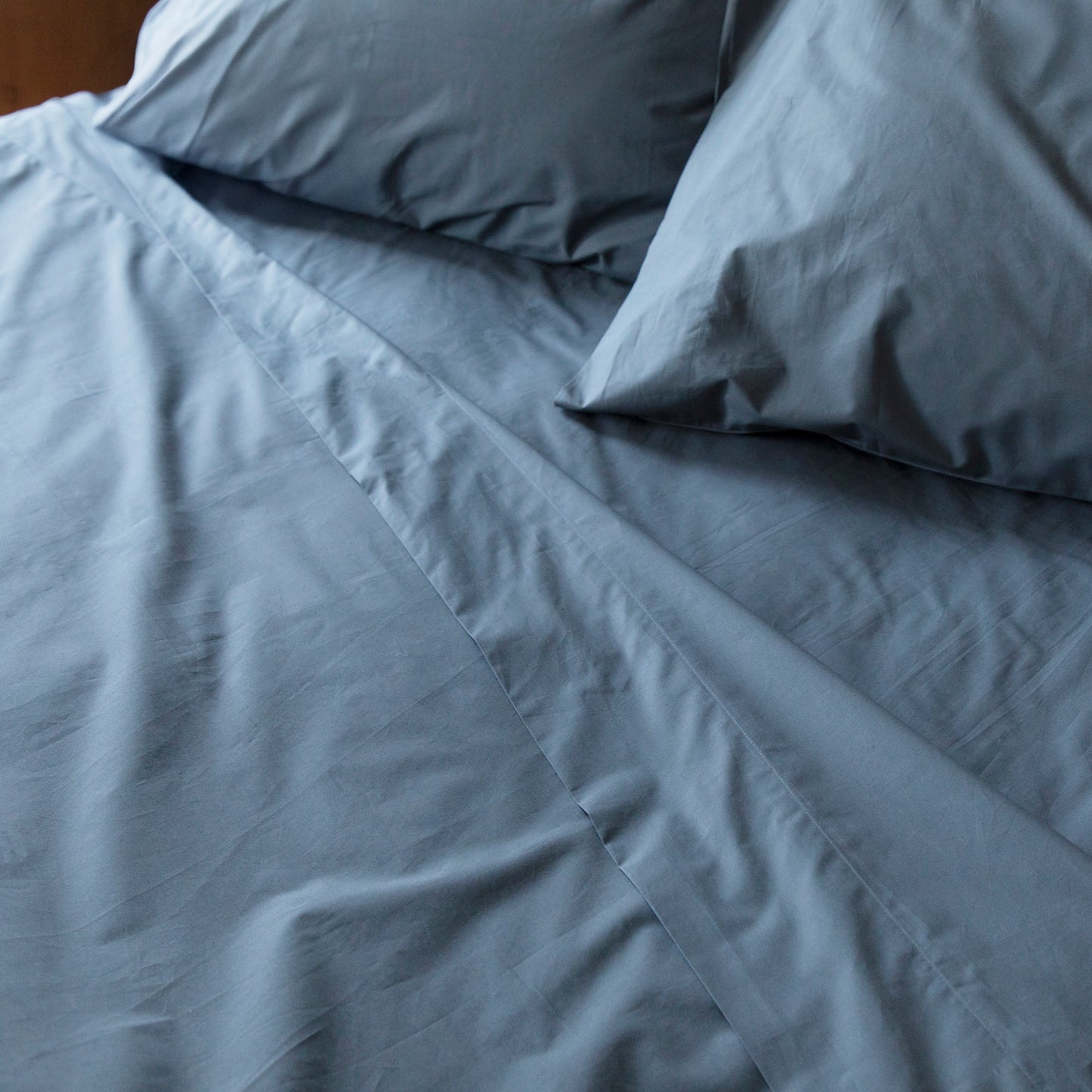 100% Pure Cotton GOTS certified Sargasso Blue bedding set with folded flat sheet with two pillows on a bed