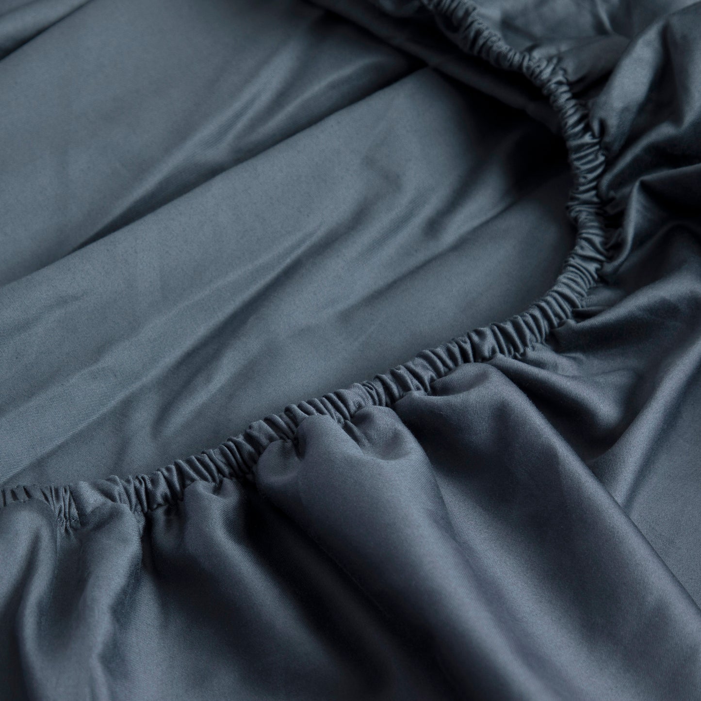 Close-up of Sargasso Blue 100% Pure Cotton GOTS certified fitted sheet with elastic waistband
