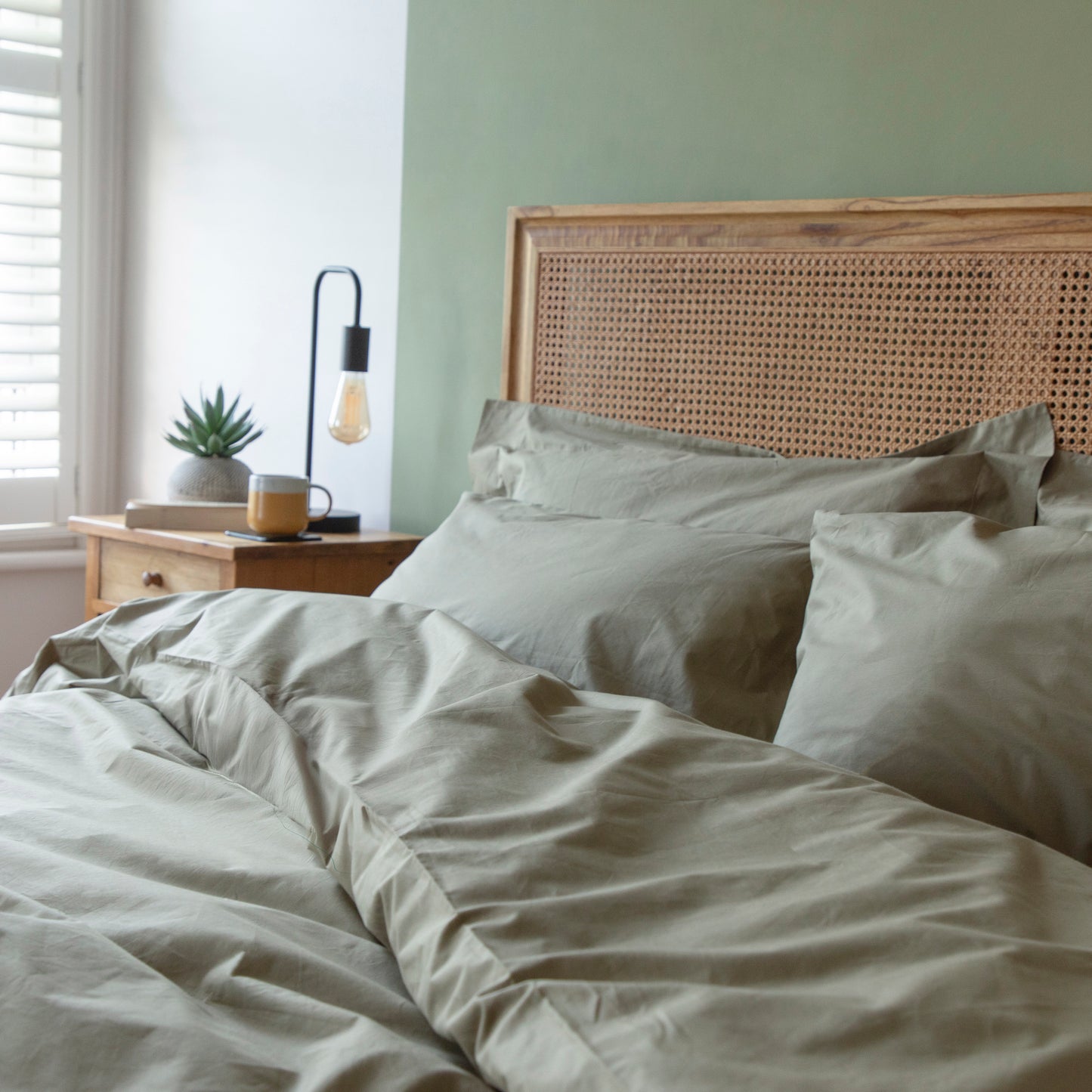 Bedroom with a wooden headboard and light green Seafern 100% pure organic cotton duvet cover set bedding