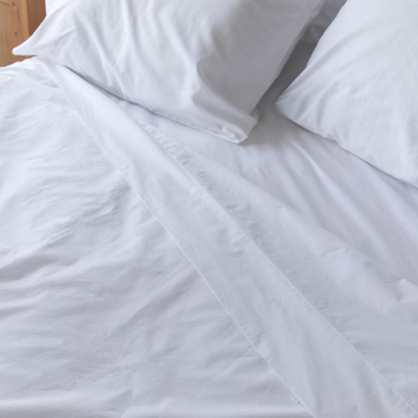 Sea Salt white flat sheet bedding set with pillows on a bed