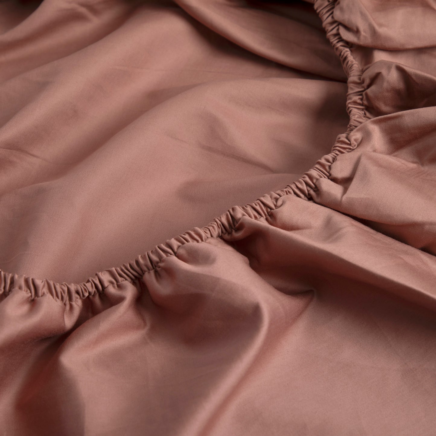 Close-up of a dune shadow coloured pure cotton fitted sheet with a smooth texture – Linen Bay UK