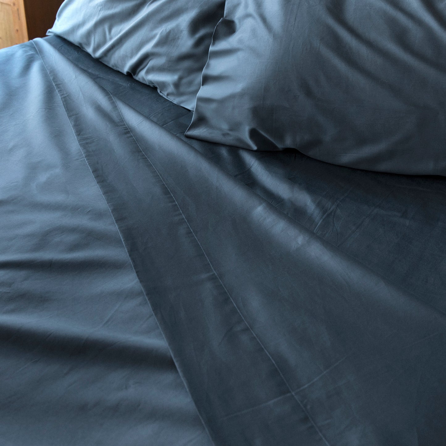 Close-up of sargasso blue bedding with pillows on a bed – Linen Bay UK