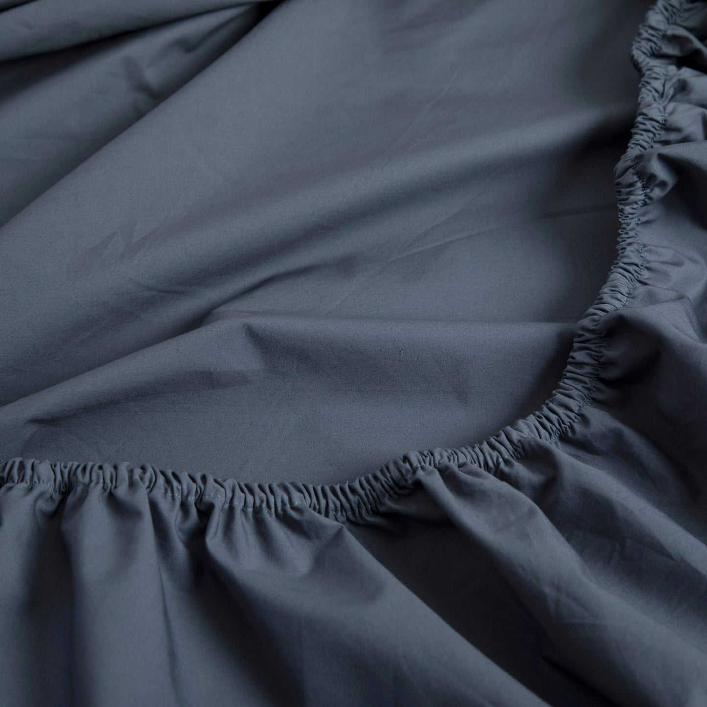Close-up of a sargasso blue pure cotton fitted sheet with a ruffled edge  – Linen Bay UK