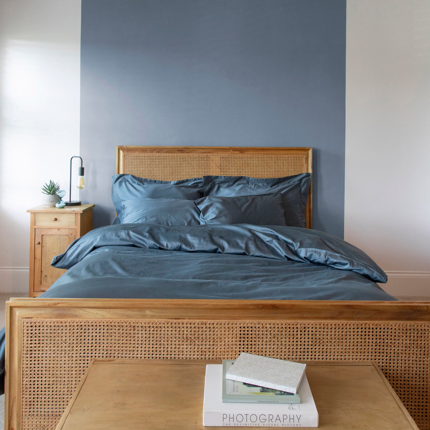 Bedroom with wooden bed frame, sargasso blue bedding, and nightstand – Linen Bay UK