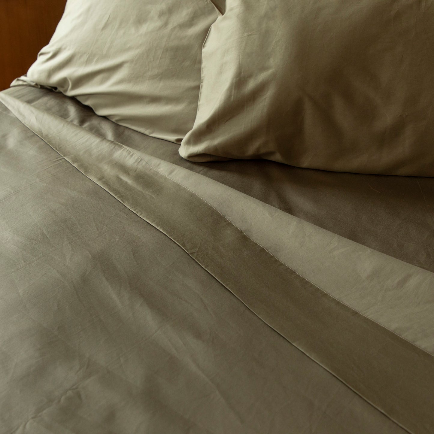 Close-up of sea fern green bedding with pillows on a bed – Linen Bay UK
