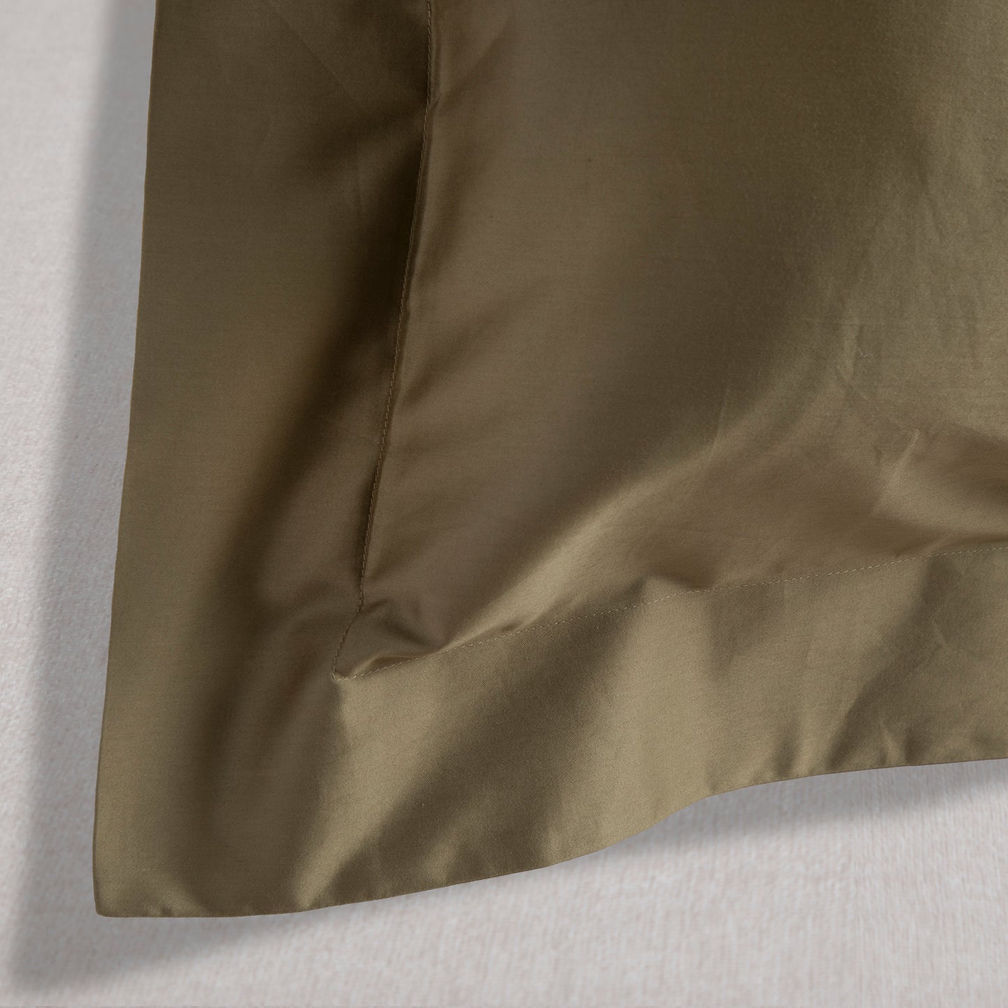 Close-up of sea fern green cotton Oxford pillowcase with a subtle texture on a white background – Linen Bay UK